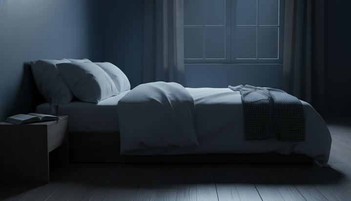 Сон влияет на долголетие сильнее, чем диета и физическая активность Пустая кровать в темной спальне ночью. Лунный свет падает из окна на пол. На прикроватной тумбочке стоят книга и стакан воды.