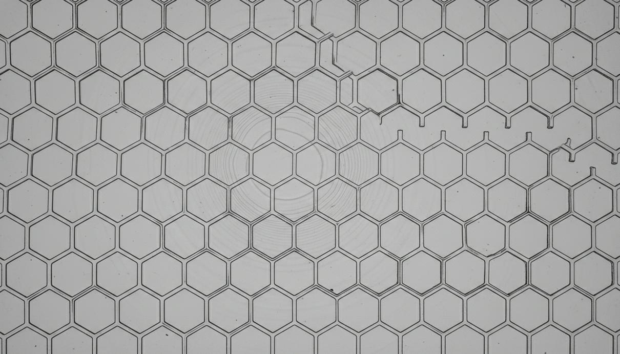 Тонкая магнитная пленка с гексагональной решеткой из микроскопических отверстий, создающая узор пчелиных сот.